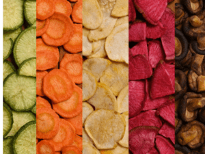 A variety of vegetable chips in different colors, lined up side by side.