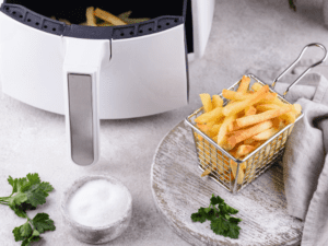 A close-up view of a basket of fries next to an air fryer.