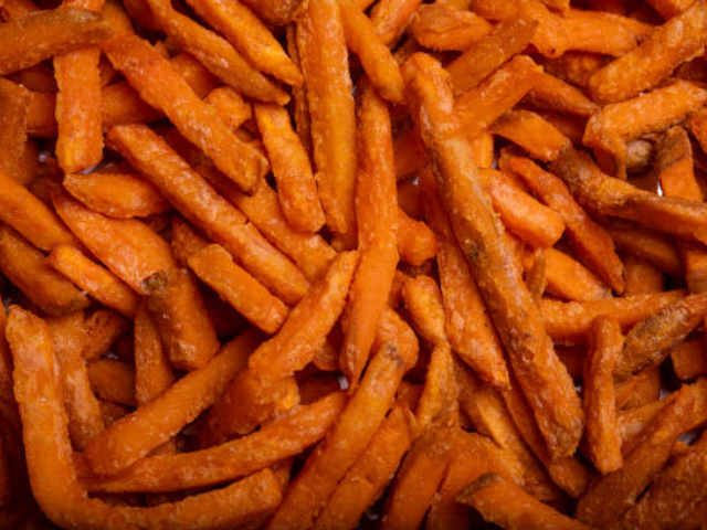 Close-up of frozen sweet potato fries, showcasing their bright orange color and texture.