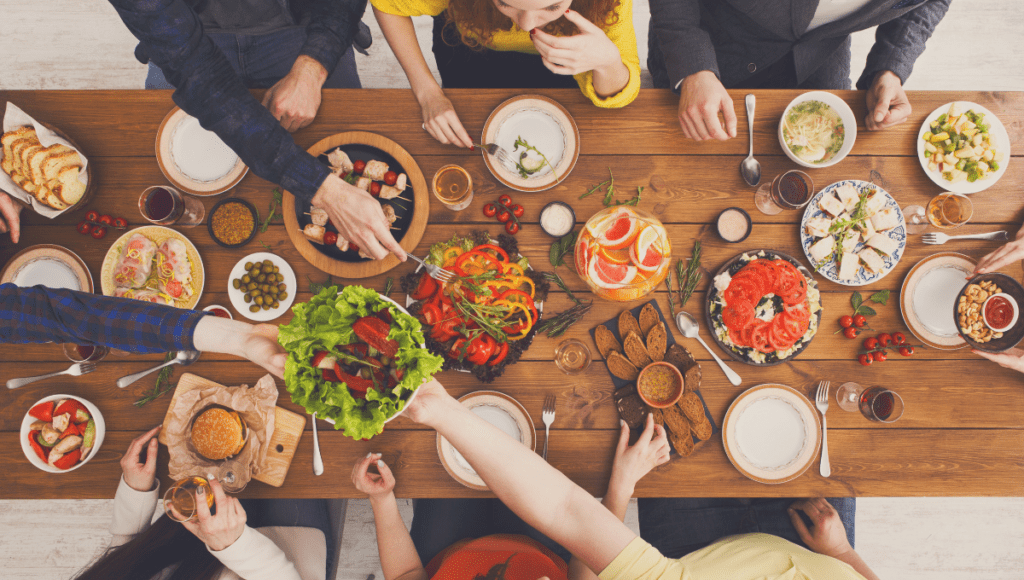A vibrant dining table with a variety of dishes shared by a group of people.