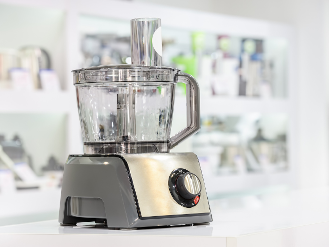 A modern, sleek food processor on display in a kitchen store.