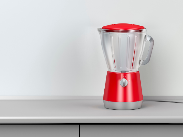 A sleek red blender placed on a gray countertop with a white background.