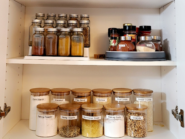 A neatly organized pantry shelf filled with labeled jars of baking essentials and spices.