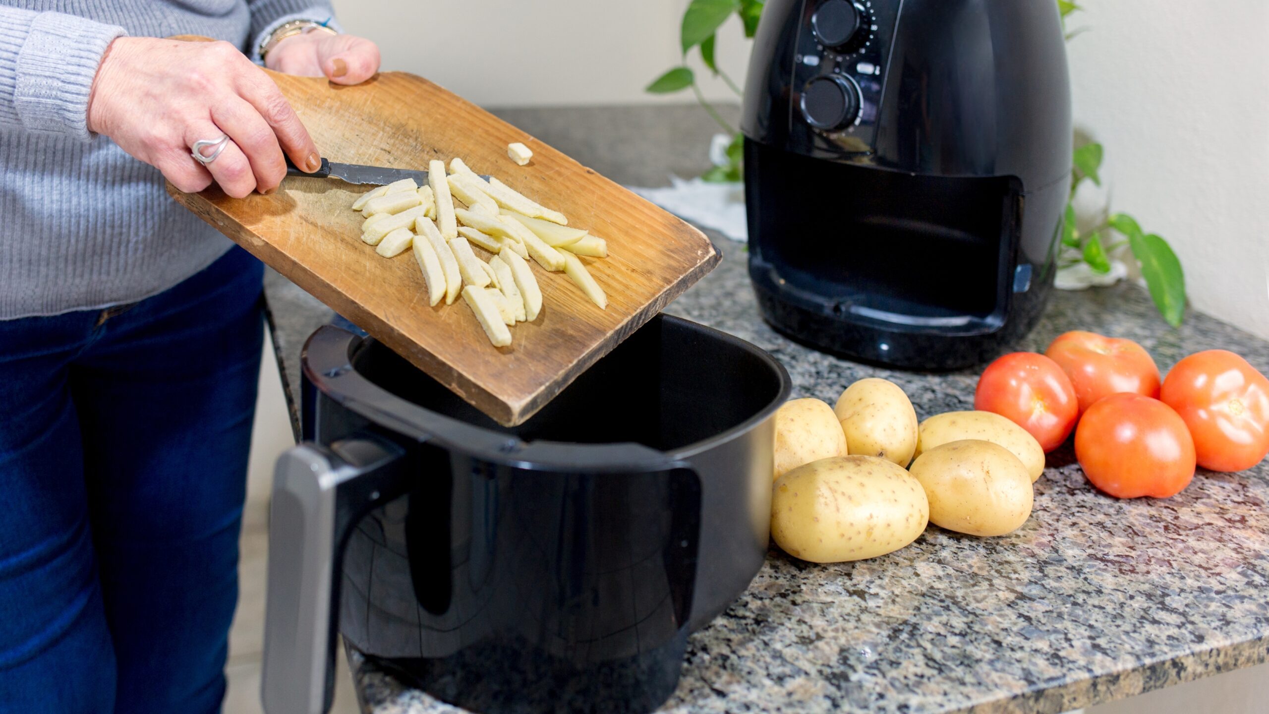 woman using air fryer to cook french fries